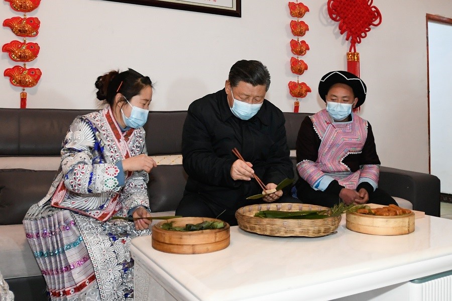 2021年2月3日下午，習近平在貴州畢節(jié)市黔西縣新仁苗族鄉(xiāng)化屋村苗族村民趙玉學家，同一家人邊聊家常邊制作當?shù)貍鹘y(tǒng)節(jié)日食品黃粑。新華社記者 李學仁 攝
